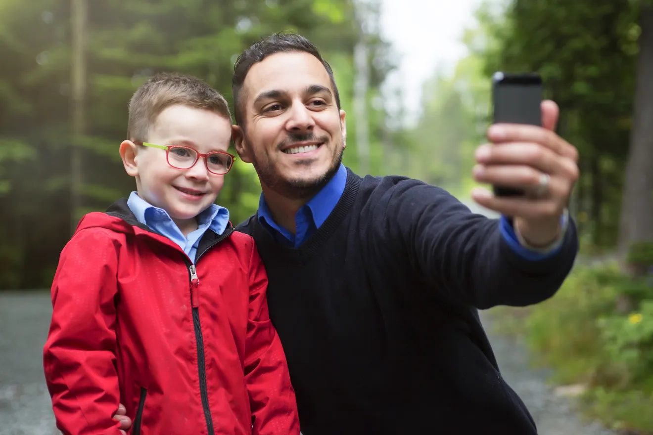 Un père et son fils prennent un égoportrait en forêt